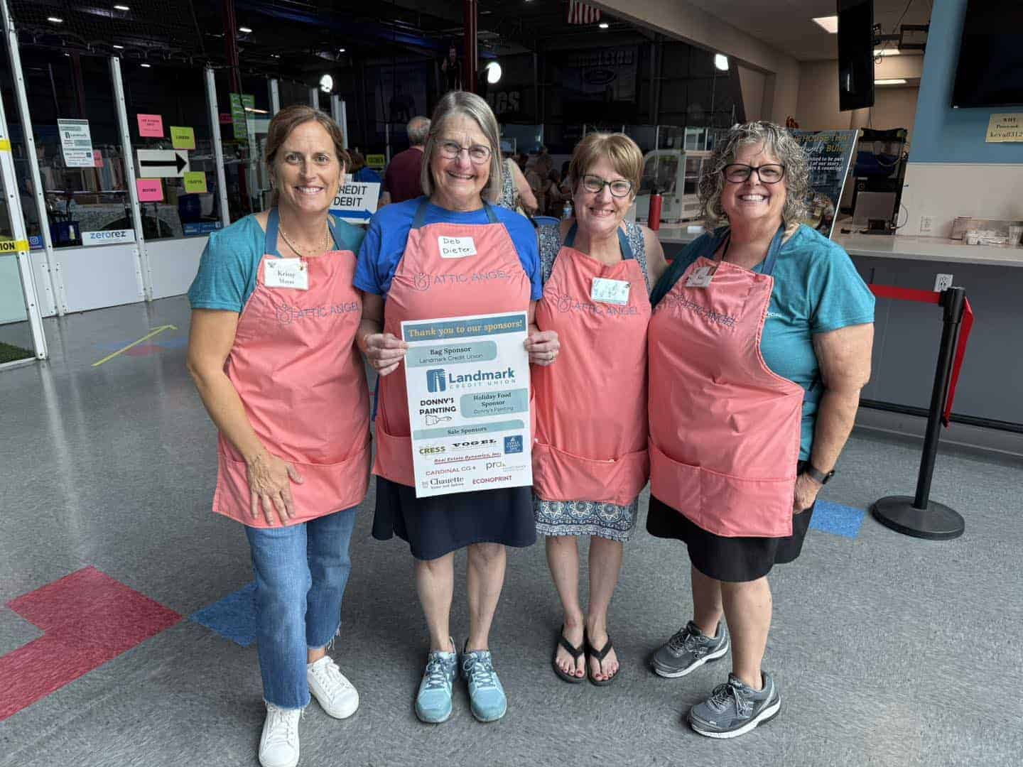 4 women in pink aprons