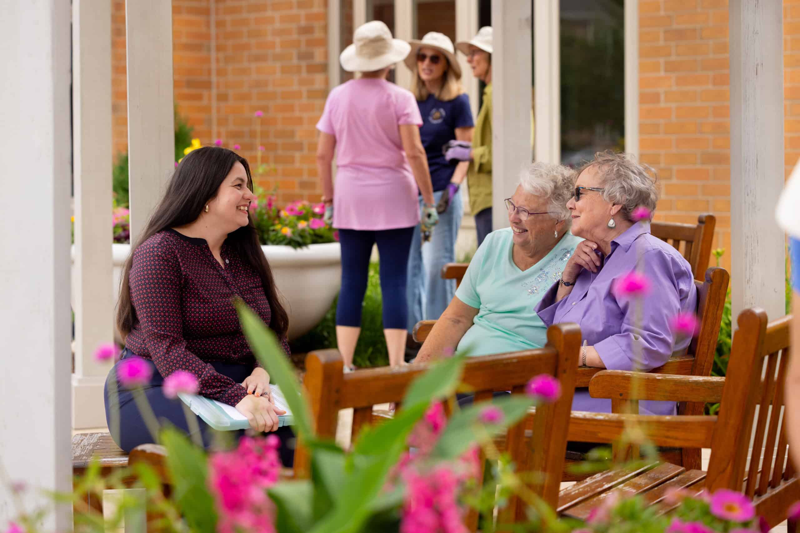 young woman sitting with older adult women outdoors